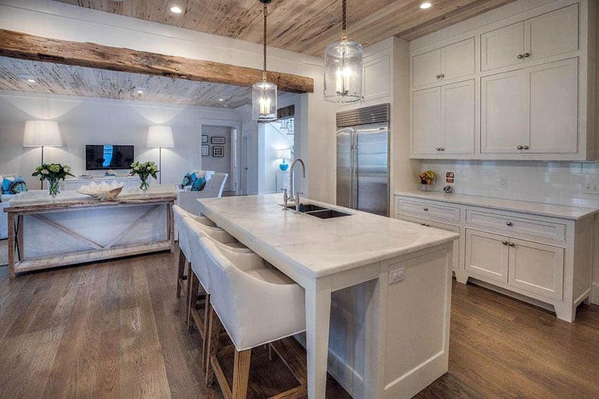 Small open plan cottage kitchen with white cabinets and wood flooring