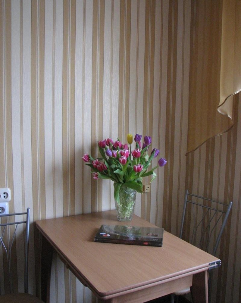 Обеденный столик у стены с полосатыми обоями