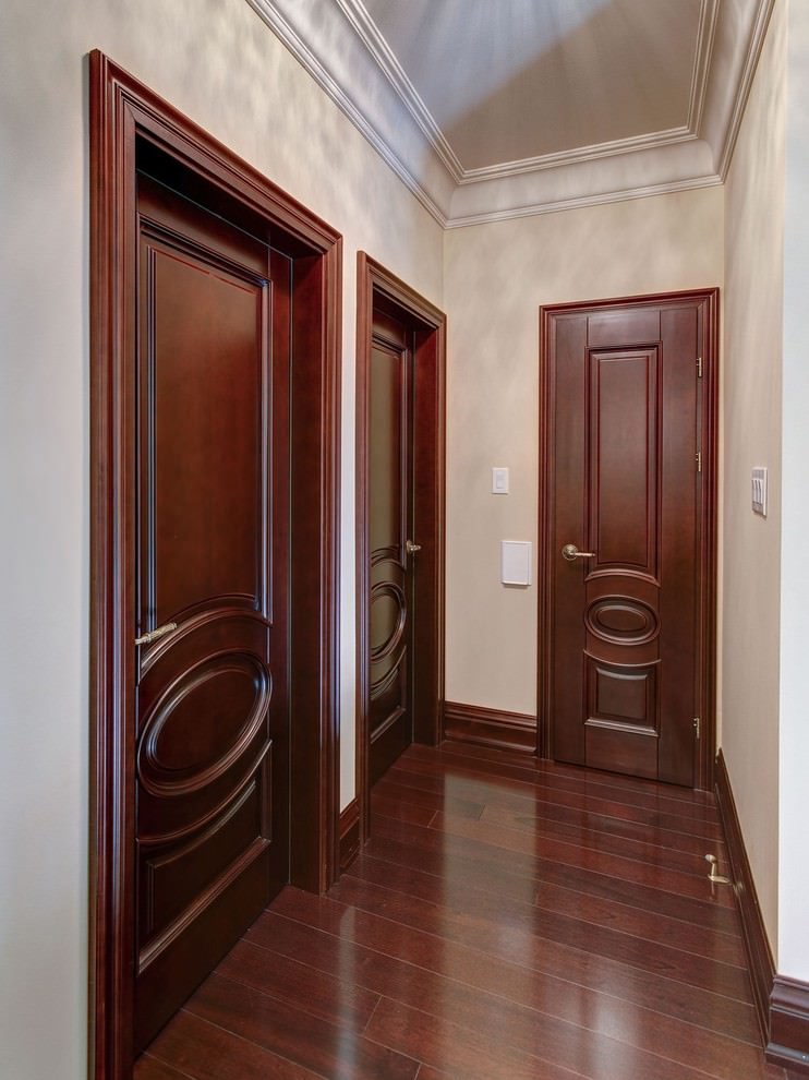 Деревянные двери темного цвета в узком коридоре квартиры