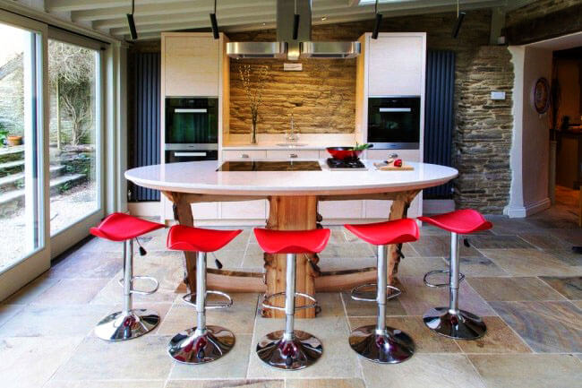 Фото дизайнерского кухонного острова со столешницей из искусственного камня с варочной панелью и деревянным основнием